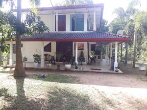 Yaluwa Tourist Rest & cooking class في أنورادابورا: منزل به شرفة مع نباتات الفخار