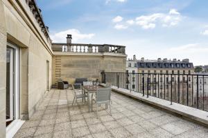 a patio with a table and chairs on a balcony at Le Nid du Roi - Appartement terrasse - Versailles in Versailles