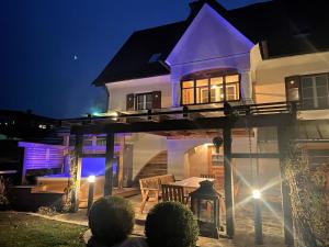 Eibiswalddas "Ferienhaus Eibiswald" Landhaus Refugium im Schilcherland - Sauna und Spa的一间晚上在院子里带桌子的白色房子