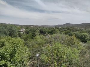 uma vista para uma floresta com uma casa à distância em La Guarida em La Bolsa