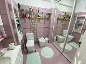 a pink bathroom with two toilets and a shower at Durrës BelleVue 3 bdm Apartment in Durrës