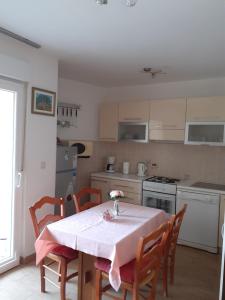 a kitchen with a table with a pink table cloth on it at CENTAR A. Mažuranića 1 Novi vinodolski in Novi Vinodolski