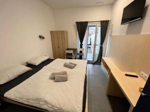 マリボルにあるVilla Magdalena apartments & rooms GARNI HOTELのベッドとタオル2枚のある寝室