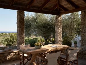 a wooden table and chairs on a patio at Villaggio Studios & Apartments in Vasilikos