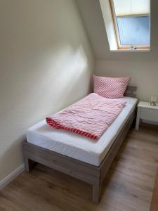 a small bed in a room with a window at Ferienhaus Osterende in Bordelum