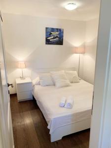 a bedroom with a white bed with two white pillows at Holiday Apartment in Nerezine