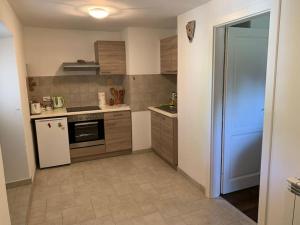 a small kitchen with a stove and a refrigerator at Holiday Apartment in Nerezine