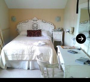 a bedroom with a large white bed and a desk at The York Hotel in Wolverhampton
