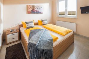 um quarto com 2 camas com lençóis amarelos e cinzentos em Michels Haus Kleine Auszeit em Norderney