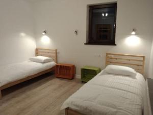 1 Schlafzimmer mit 2 Betten, einem Spiegel und einem Fenster in der Unterkunft Antówka in Tolkmicko