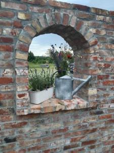 a brick wall with two potted plants on it at Antówka in Tolkmicko