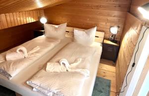 een kamer met 2 bedden in een cabine met handdoeken bij Hohenwaldeck Seeblickrefugium in Schliersee
