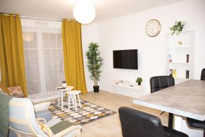 a living room with a table and a dining room at Superbe appartement entre Paris et Disneyland in Gagny