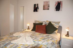 a bedroom with a bed with pillows and pictures on the wall at Superbe appartement entre Paris et Disneyland in Gagny