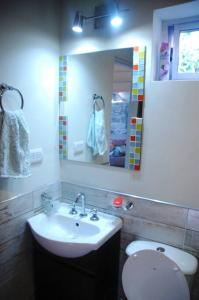 a bathroom with a sink and a toilet and a mirror at Koba, una experiencia memorable in Potrero de los Funes