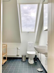 a bathroom with a toilet and a sink at Familjevänligt hus med pool och tennisbana in Torekov