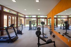 - une salle de sport avec tapis de course et vélos elliptiques dans une pièce dotée de fenêtres dans l'établissement Zorah Beach Hotel, à Trairi