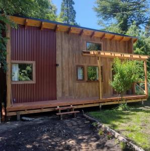 une grande cabine en bois avec une terrasse dans une cour dans l'établissement Casa en entorno de bosque, cerca de playas y cerros, à San Carlos de Bariloche