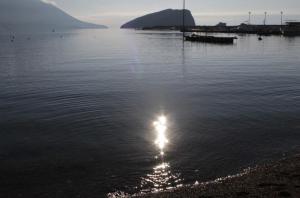 a body of water with the sun reflecting in the water at Apartman Bećir in Budva