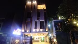 a building with a neon sign in front of it at night at Jazzy Beach Guest House in Visakhapatnam