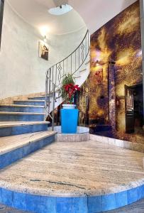 a staircase in a building with a blue pot with a plant at Residence La Torre Del Sole in Mazara del Vallo