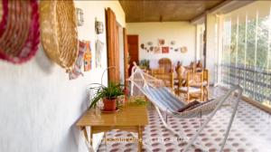 a porch with a hammock and a table and chairs at B&B Villa Tina in SantʼOmero