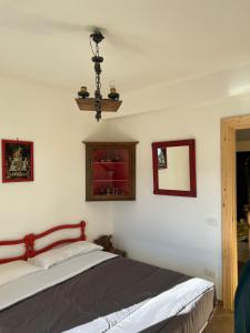 1 dormitorio con cama y espejo en la pared en Casa vacanze “La baita”, en Roccaraso