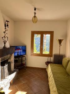 a living room with a fireplace and a tv at Casa vacanze “La baita” in Roccaraso