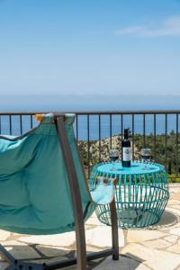 una silla y una mesa con una botella de vino en Sapphire Blue Villa, en Kalamitsi