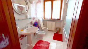 La salle de bains est pourvue d'un lavabo et de toilettes. dans l'établissement B&B Villa Tina, à SantʼOmero