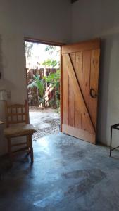 - une porte en bois dans une chambre avec une chaise dans l'établissement Casa de Kai Mazunte, à Mazunte
