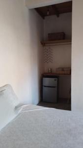 1 dormitorio con cama blanca y estante en Casa de Kai Mazunte, en Mazunte