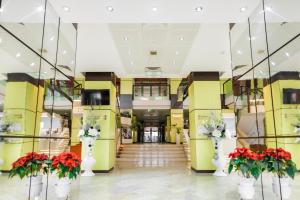 a lobby with red and white flowers in white vases at Caprioara Spa&Wellness Resort in Covasna