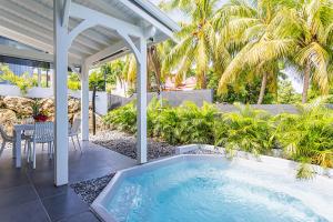 a swimming pool on the patio of a house at Villa Orchidées in Sainte-Anne