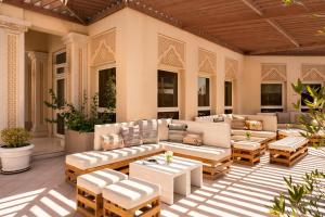 eine Terrasse mit Sofas und Tischen auf einer Veranda in der Unterkunft Mövenpick Hotel Doha in Doha