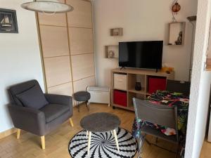 a living room with a tv and chairs and a table at Gruissan les MARINES II in Gruissan