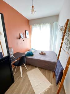 1 dormitorio con cama, escritorio y ventana en Cosy Californie en Niza