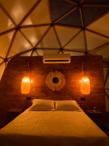a bedroom with a bed with two lights and a fan at Şelale Park Gizli Bahçe Glamping in Viransenir