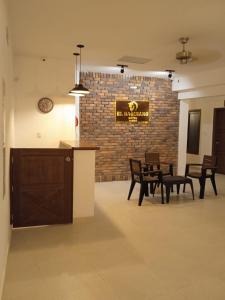 a room with tables and chairs and a clock on a brick wall at Hotel El Baquiano in San Juan de Arama