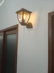 une lumière sur un mur à côté d'une fenêtre dans l'établissement Hotel El Baquiano, à San Juan de Arama
