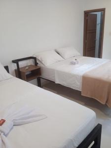 duas camas num quarto de hotel com aviso em Hotel El Baquiano em San Juan de Arama