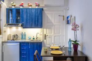 une cuisine avec des placards bleus et une table en bois dans l'établissement CapSaSalBegur137 en Playa Privada Piscina del Mar, à Begur