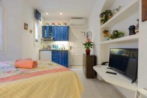 巴古爾的住宿－CapSaSalBegur137 en Playa Privada Piscina del Mar，一间卧室配有一张床和一台电视,还设有一间厨房