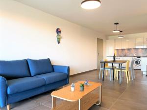 uma sala de estar com um sofá azul e uma mesa em BEL' ORIZONTE proche centre ville et plage em Propriano