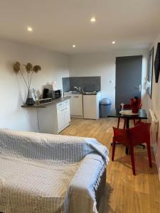 um quarto com uma cama, uma mesa e uma cozinha em studio rouge em Arras