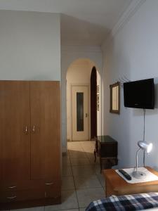 a room with a bed and a dresser and a television at Mavipagi in Verona