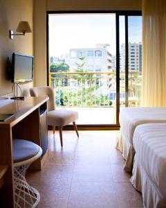 a hotel room with a desk and a large window at Hotel Almirante in Alicante