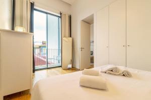 una camera con letto bianco e balcone di Republica I by Innkeeper a Porto