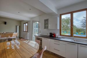 una cucina con un tavolo di legno e una sala da pranzo di Crazy Villa Le Tertre 28 - Heated pool - Basket - 2h Paris - 44p a Courtalain