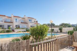 uma cerca em frente a uma casa com piscina em Casa Cabrita - Surf & Family House in Sagres em Sagres